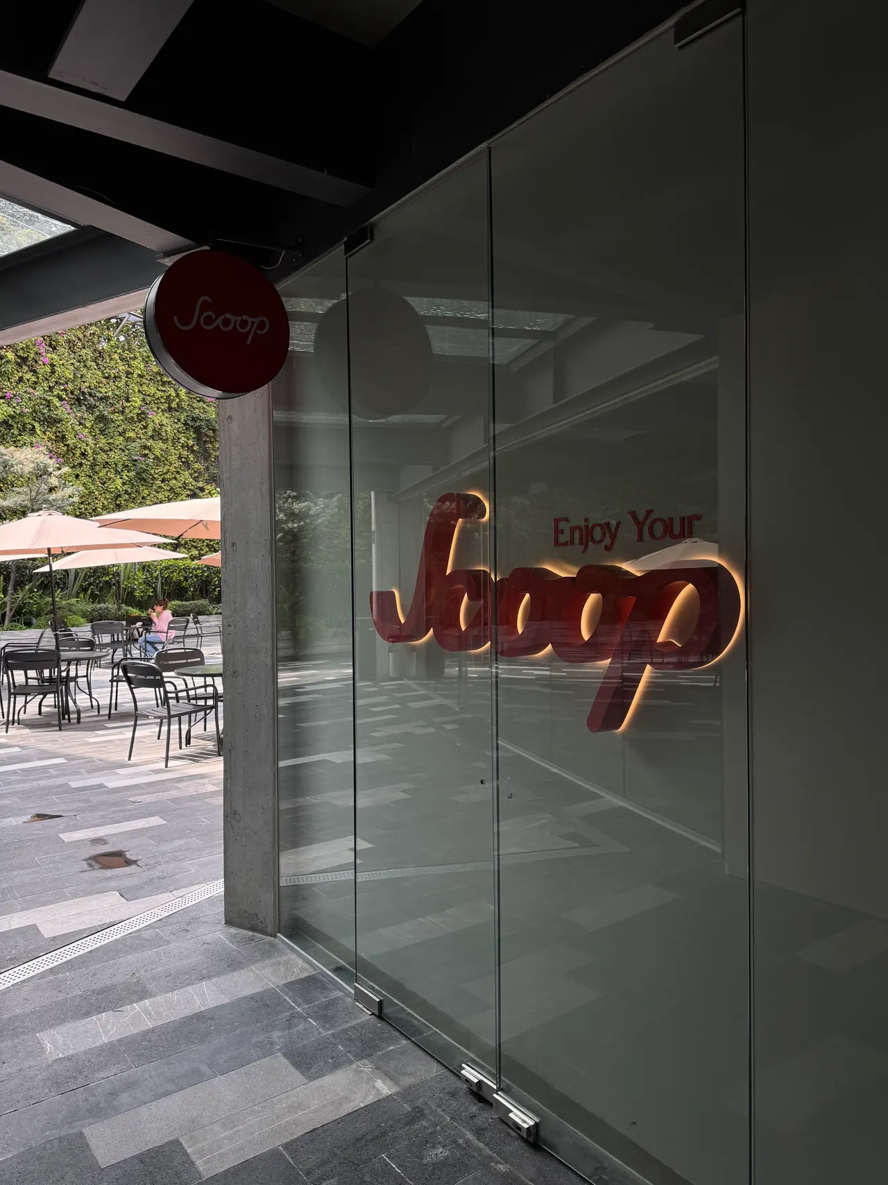Entrada de Scoop en TOBA: puertas de cristal con el letrero luminoso y la terraza al fondo
